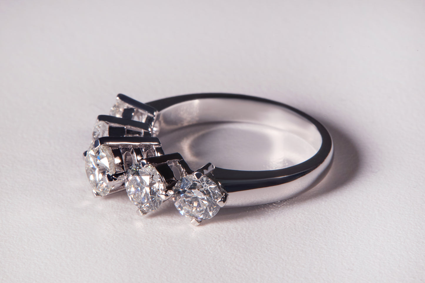 Silver ring with diamonds on a light gray background