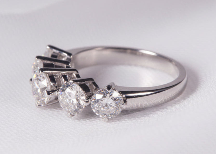 Silver ring with diamonds on a light gray background
